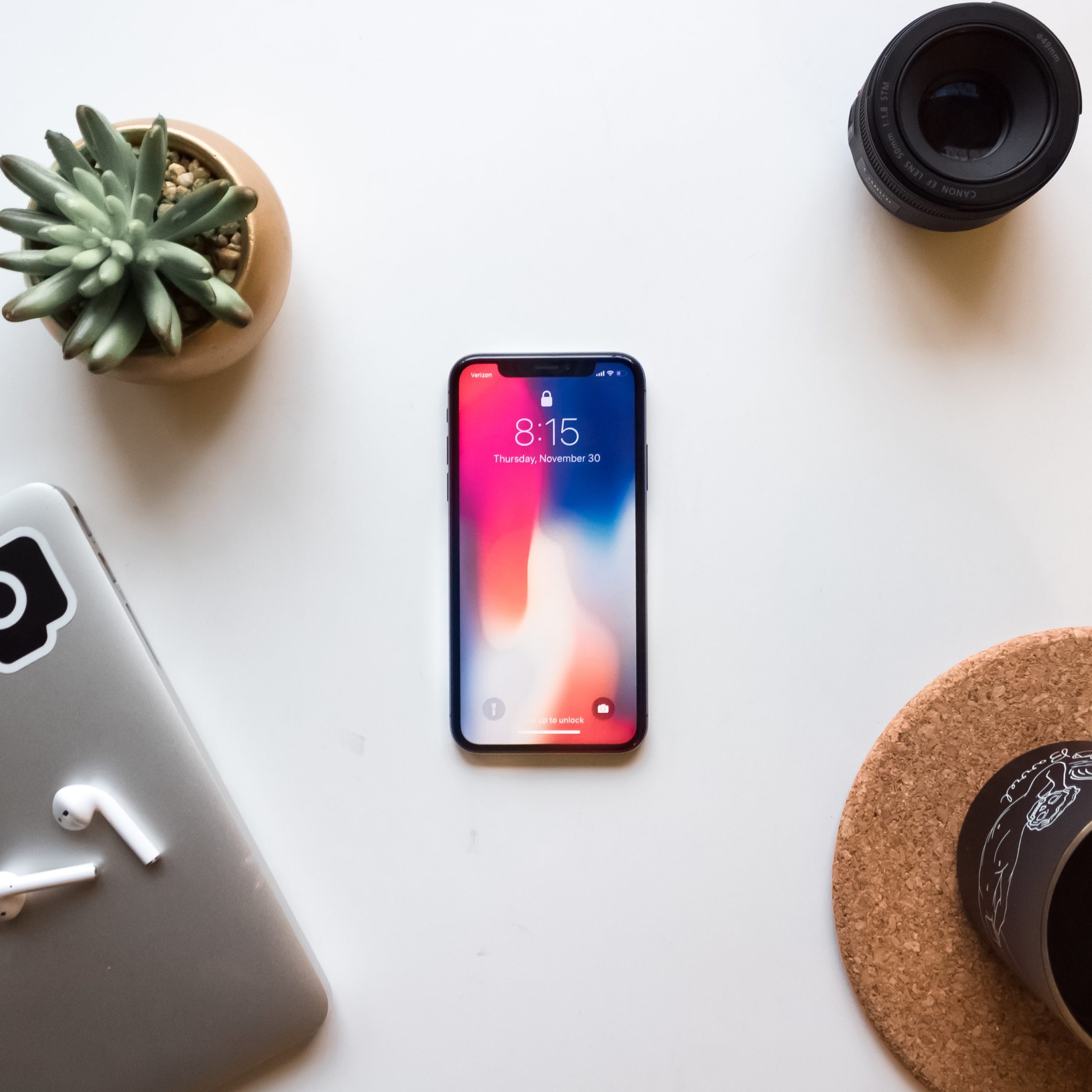 phone on desk by laptop and plants